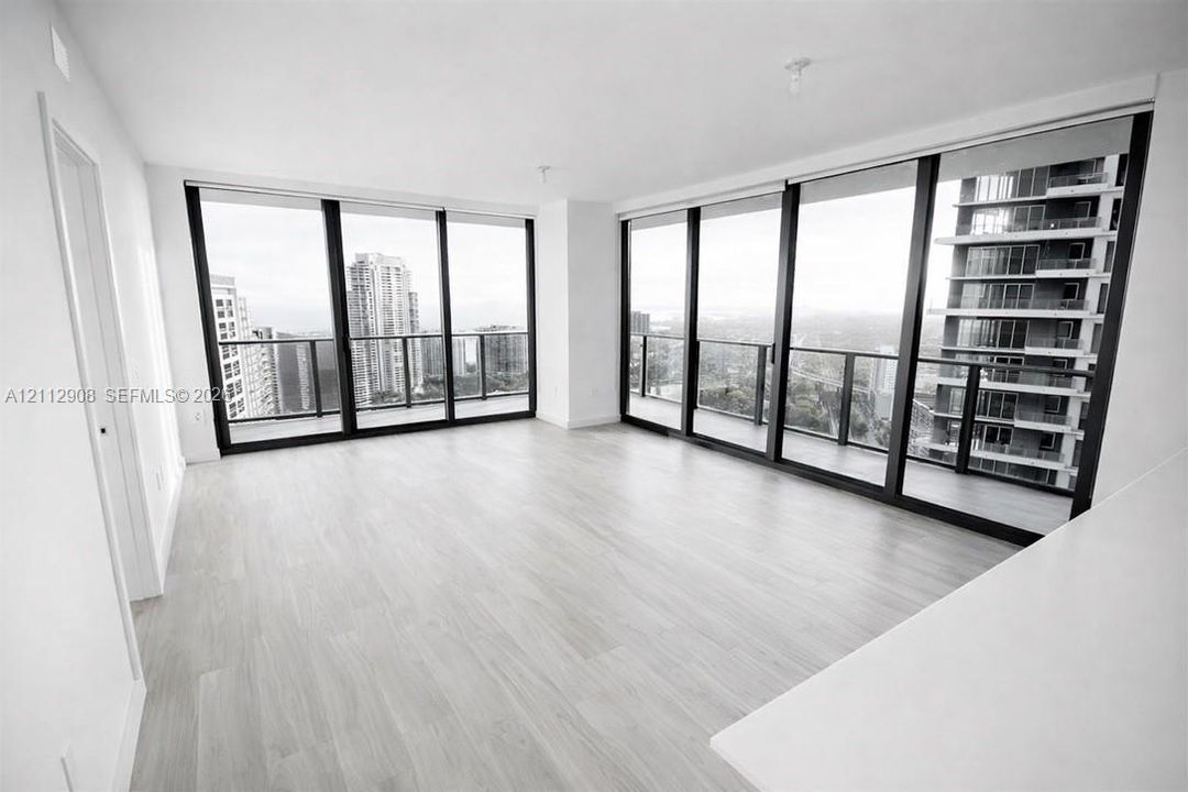 Floor-to-ceiling windows featuring black framing, wood-finish flooring, and wraparound balconies
