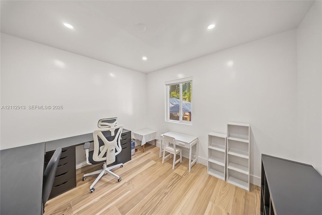 Room featuring wood-finish flooring, recessed lighting, and a single-pane window