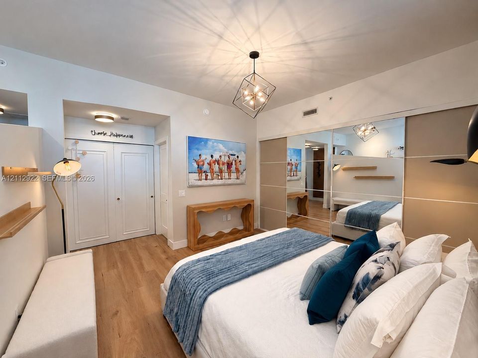 Interior featuring wood-finish flooring, geometric chandelier, built-in dual-panel closet, full-height mirrored closet doors, and floating wall shelves