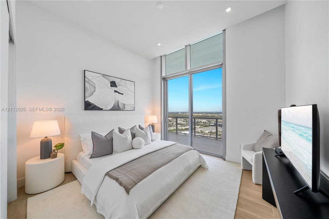 Floor-to-ceiling glass sliding doors with high-transom windows, recessed lighting, and light-toned wood-finish flooring