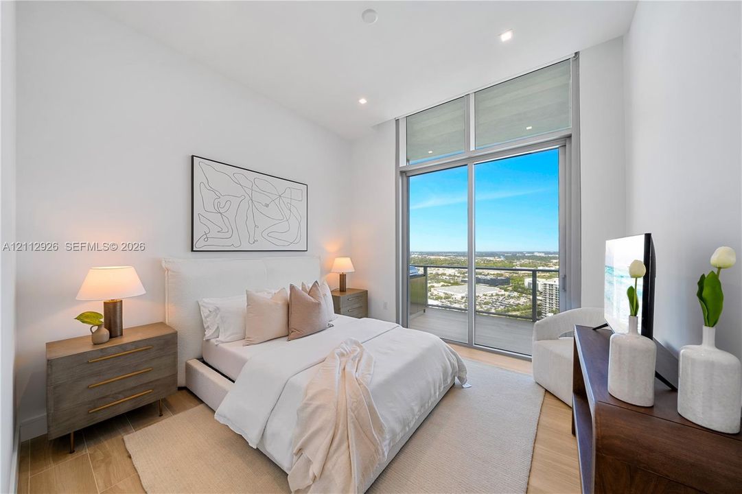 Floor-to-ceiling glass sliding doors, private balcony, wood-finish flooring, recessed lighting, and high ceilings