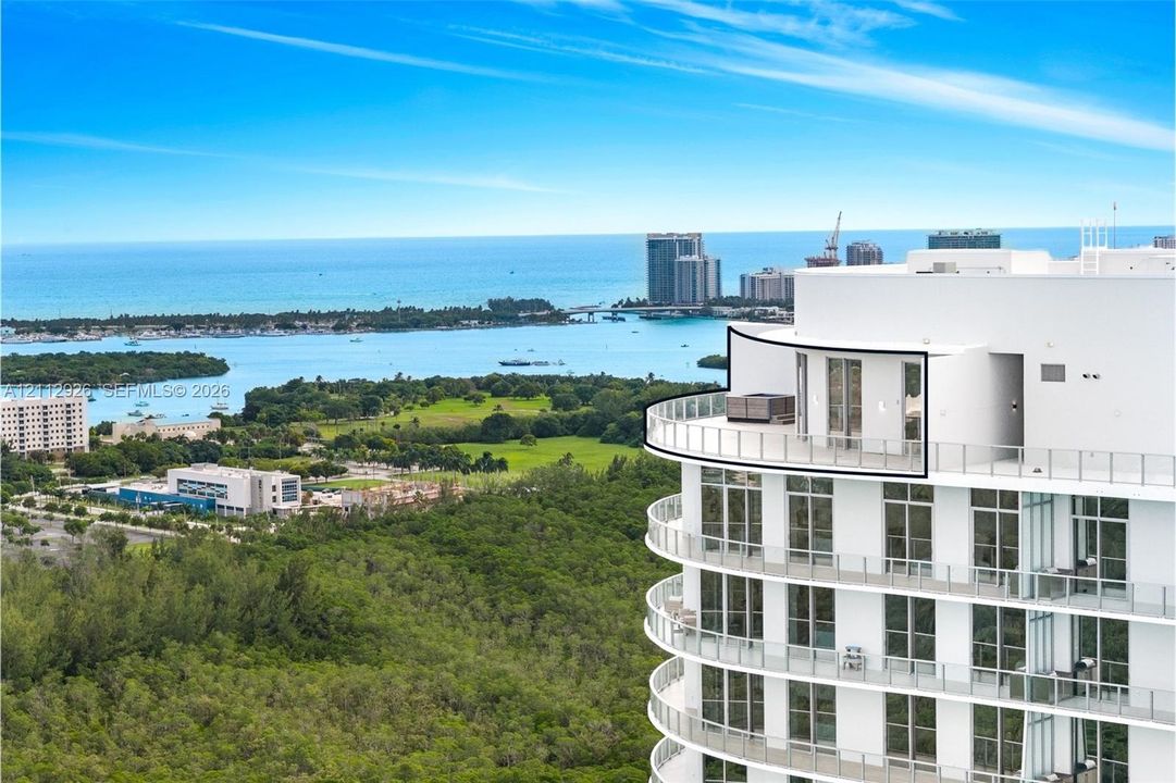 High-rise residence featuring a wrap-around balcony with glass railings, floor-to-ceiling windows, and a prominent curved exterior architectural design