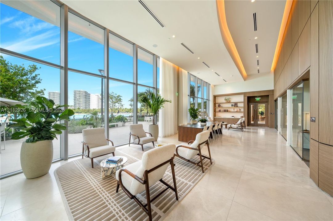 Floor-to-ceiling windows, polished stone flooring, recessed ceiling lighting, built-in recessed wall shelving, and wood-panel wall treatments