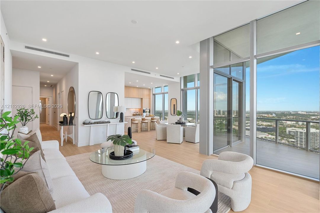 Open-concept floor plan with floor-to-ceiling glass walls, wood-finish flooring, recessed lighting, and a wrap-around balcony