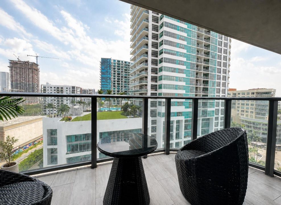 Private balcony featuring tile flooring and a glass-paneled railing