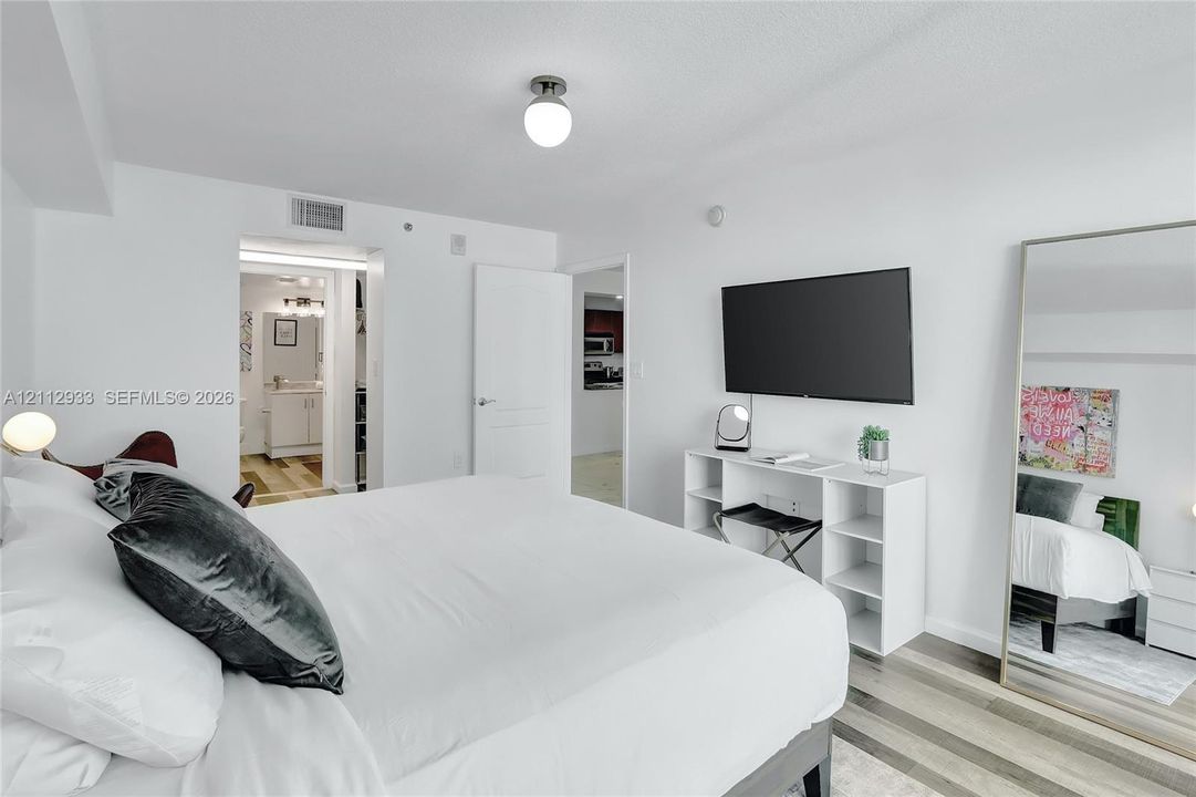 Neutral color palette featuring wood-finish flooring and a flush-mount globe ceiling light fixture