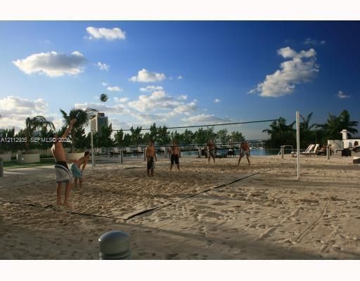 Sand volleyball court featuring professional-grade net system and manicured sand surface