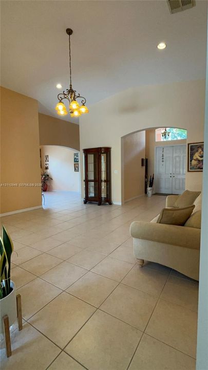 High ceilings, tile flooring, arched entryways, and a multi-arm light fixture