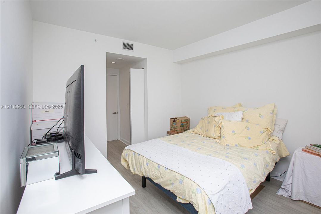 Interior space featuring neutral wall paint, wood-finish flooring, and a solid-core interior door