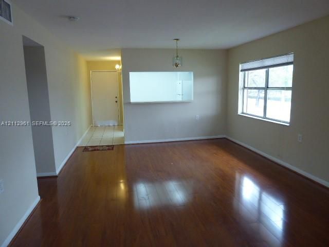Wood-finish flooring, interior pass-through window, ceramic tile entryway, and neutral wall color