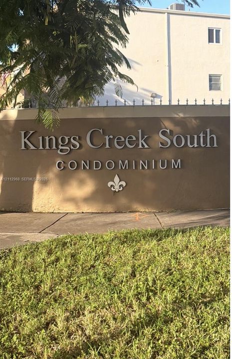 Kings Creek South signage featuring dimensional lettering, mounted on a stucco-finished wall with metal spiked fencing and ornamental detailing