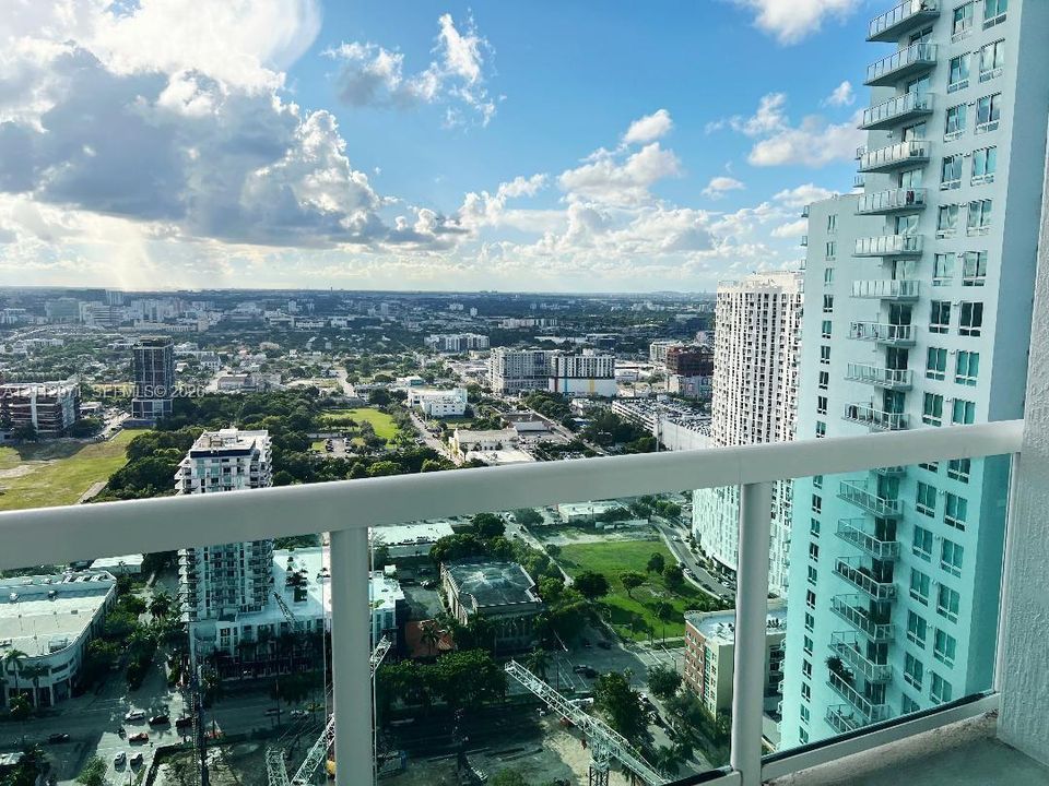Elevated balcony with glass railings and expansive cityscape exposure