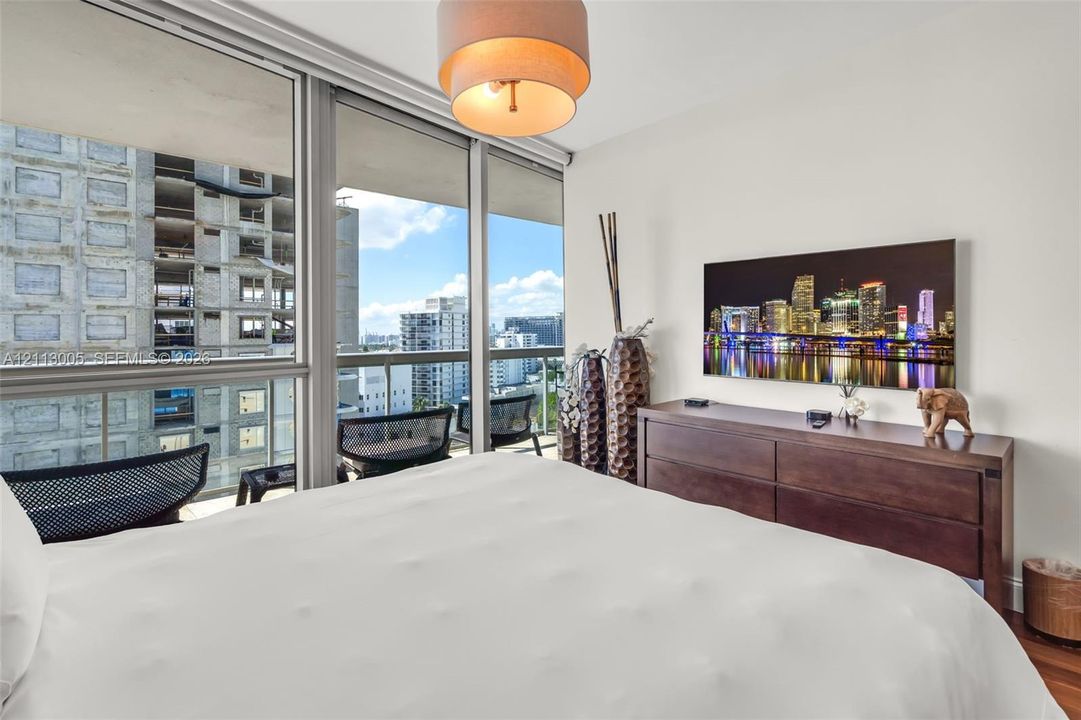 Floor-to-ceiling glass windows, recessed ceiling lighting, and private balcony access