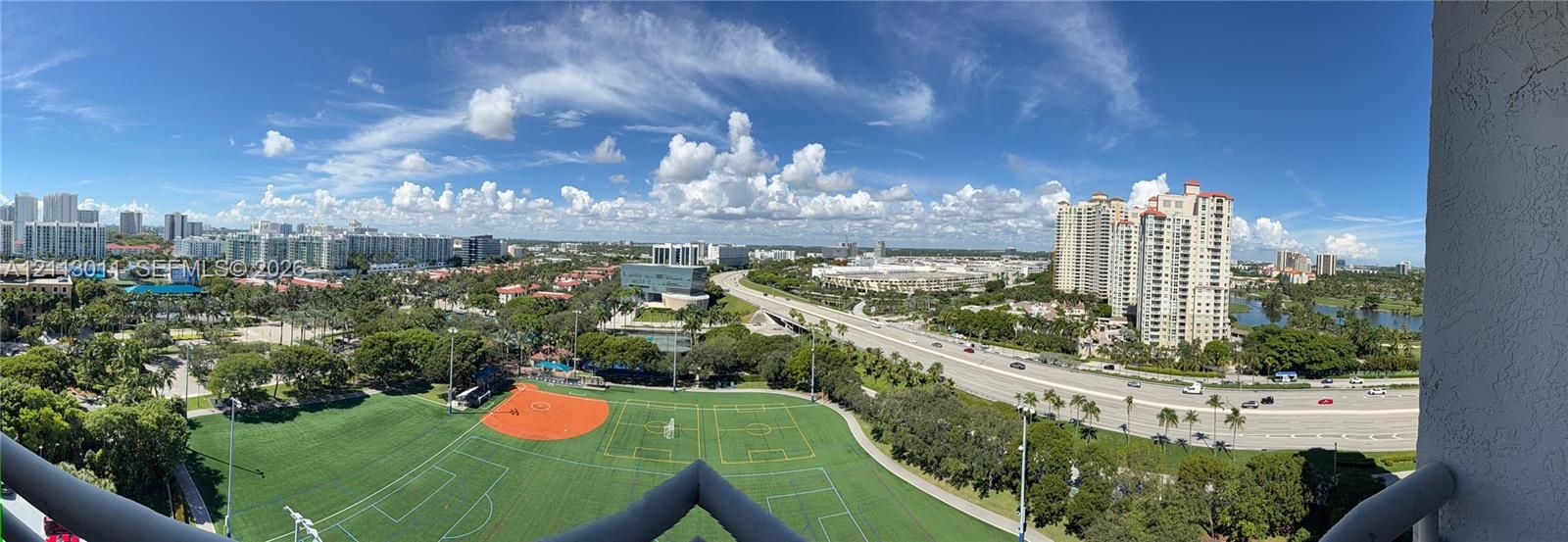 Panoramic cityscape featuring a multi-sport turf field, urban infrastructure, and surrounding high-rise structures