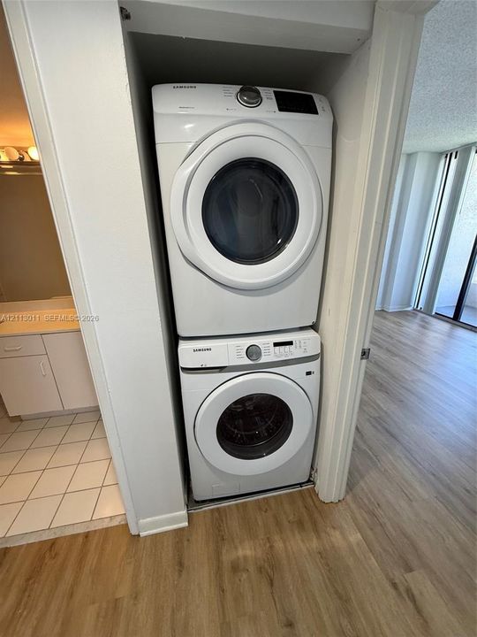 Stacked laundry center featuring a front-loading washer and dryer set