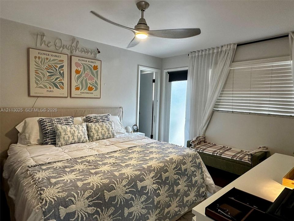 Modern three-blade ceiling fan with integrated lighting, neutral wall palette, and horizontal window blinds