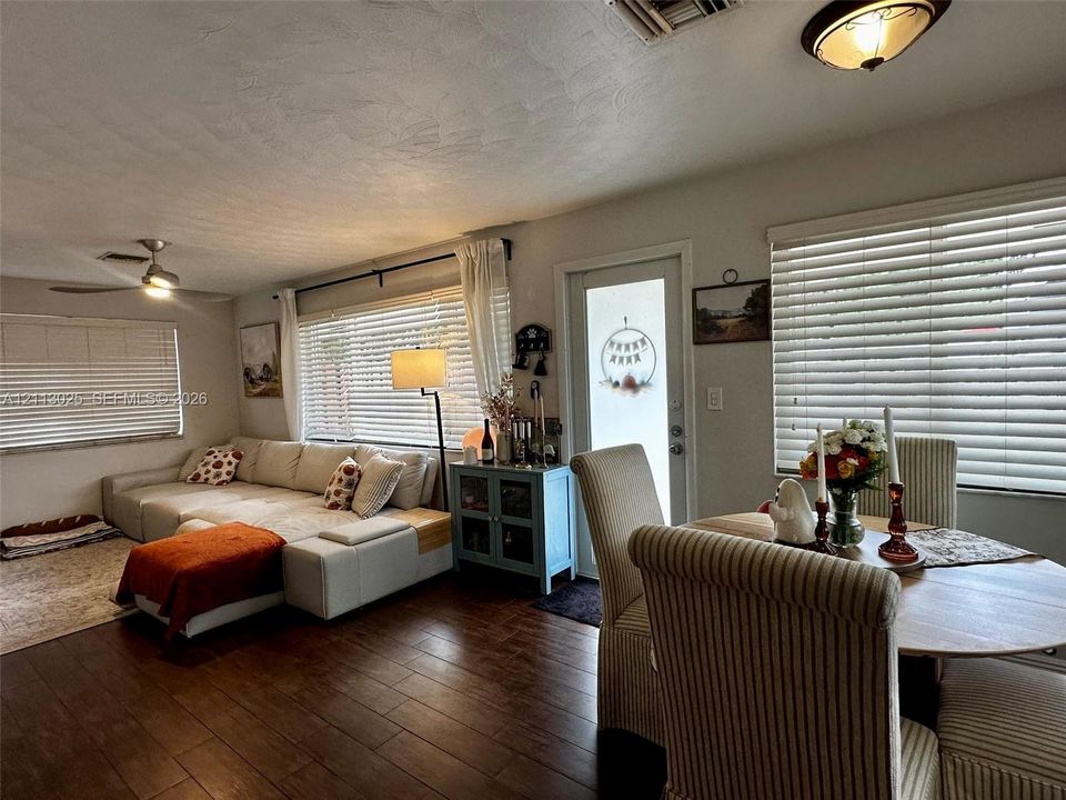 Wood-finish flooring, ceiling fan, and horizontal window blinds throughout