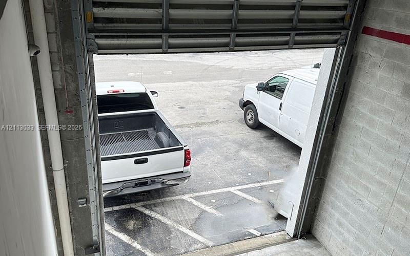 Industrial roll-up door with concrete masonry unit wall construction and exterior asphalt loading area