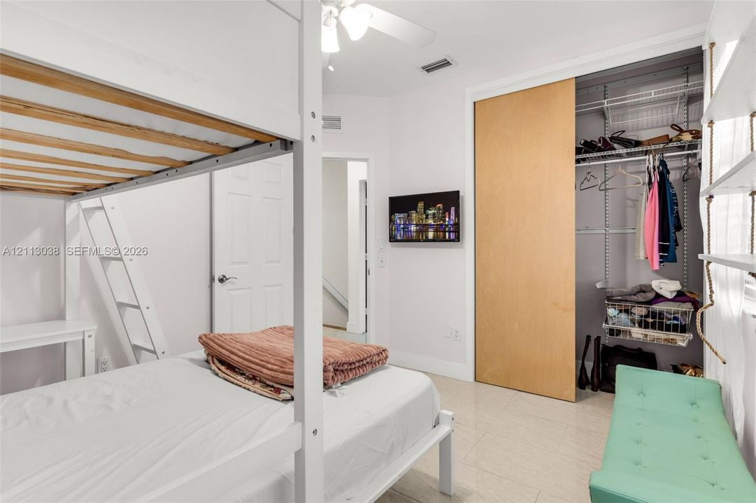 Sliding closet door with wood-finish panel, integrated wire shelving, and neutral tile flooring
