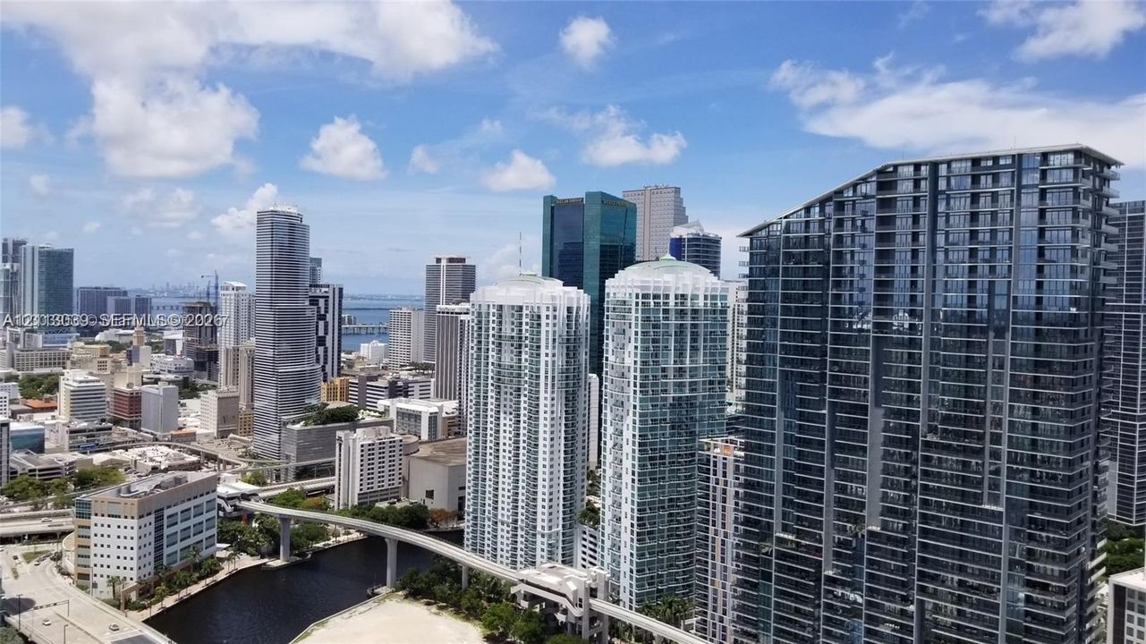 High-rise urban landscape featuring glass-clad skyscrapers, reflective facades, and waterfront proximity