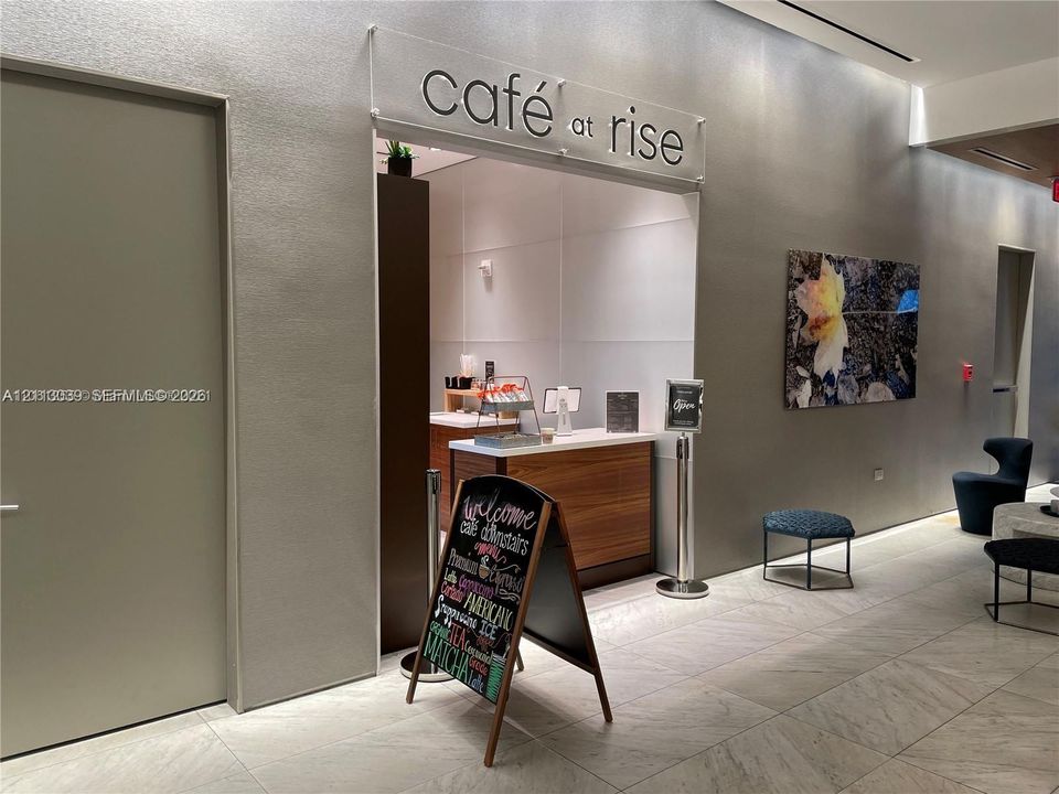 Common area featuring a built-in refreshment station with wood-finish cabinetry, stone-style flooring, and recessed ceiling lighting