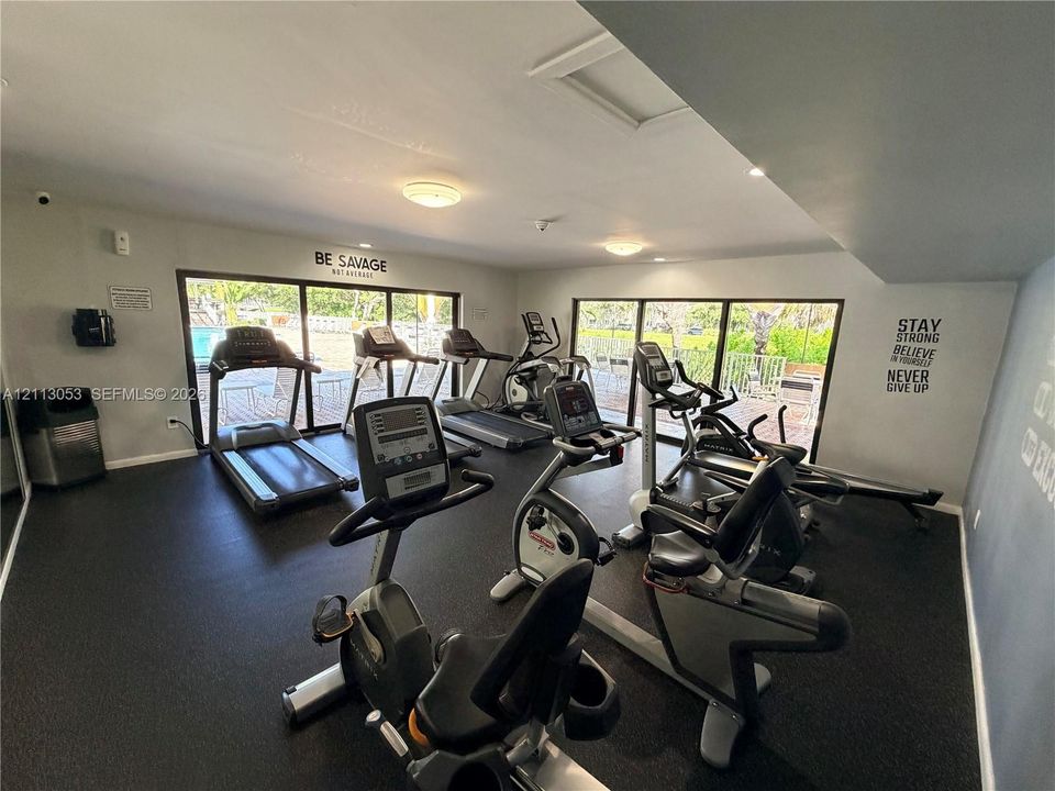 Fitness center featuring rubber flooring, expansive floor-to-ceiling windows, and recessed lighting