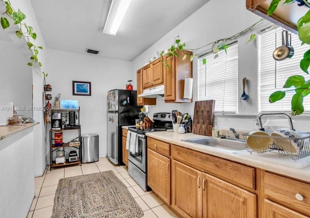 Living area featuring large format tile flooring, smooth wall finishes, and multiple windows