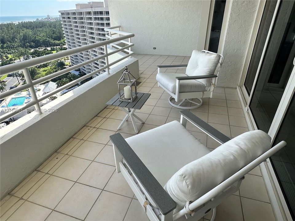 Covered balcony featuring tile flooring and a metal railing