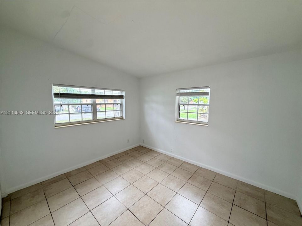 Neutral-toned ceramic tile flooring, crisp white walls, and multi-pane windows with integrated blinds