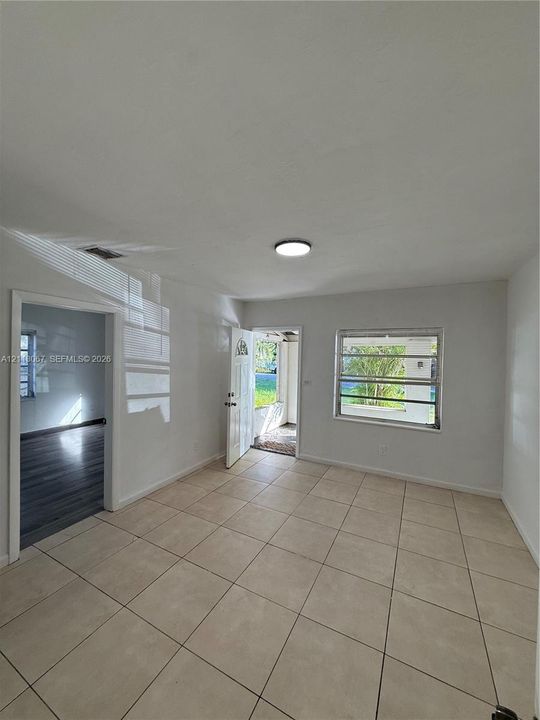 Neutral-toned tile flooring, flush-mount ceiling lighting, and horizontal sliding windows