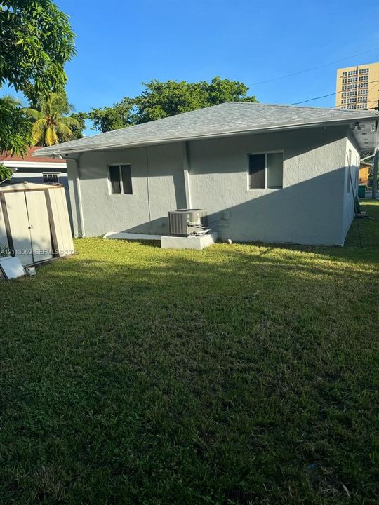 Stucco exterior siding, shingle roofing, and grass yard