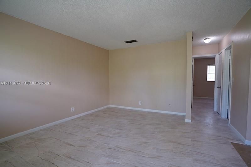 Interior room featuring neutral-toned walls, large-format tile flooring, and a ceiling-mounted light fixture