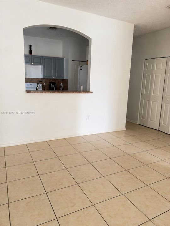 Ceramic tile flooring, arched wall pass-through, countertop breakfast bar, and double-panel closet doors