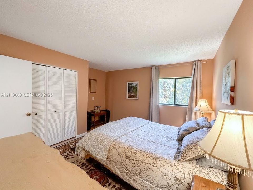 Room featuring white louvered closet doors and a single window with natural light exposure
