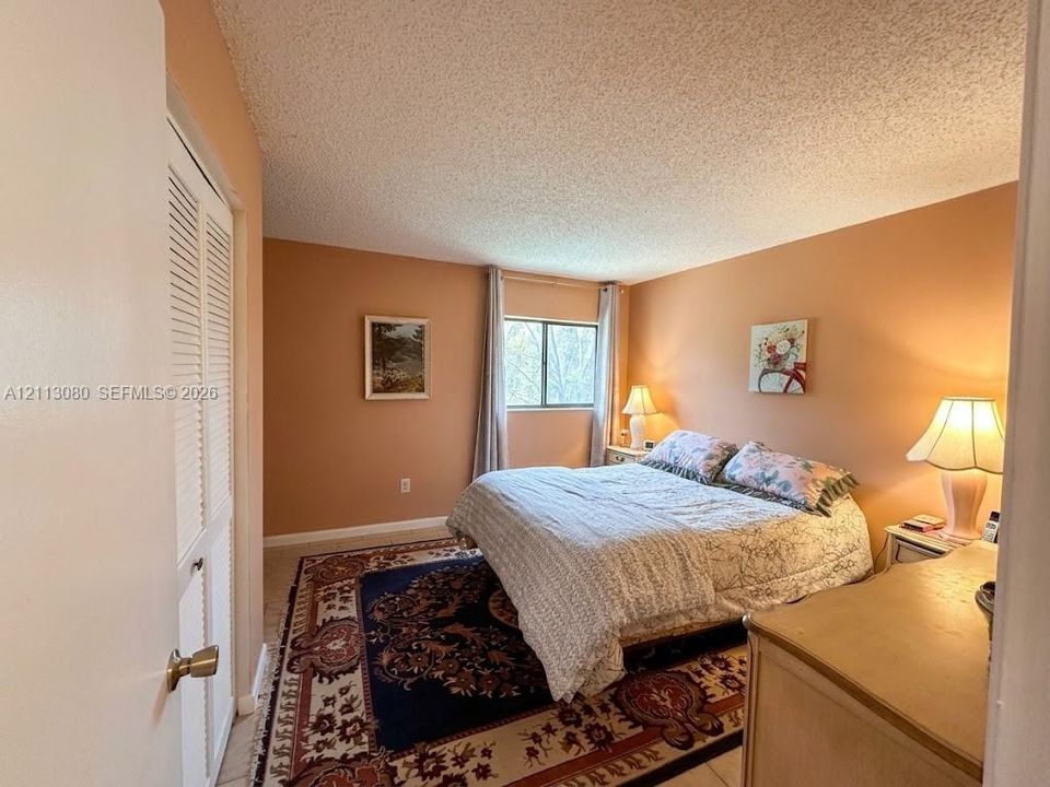 Bedroom featuring a single window and dual-panel louvered closet doors