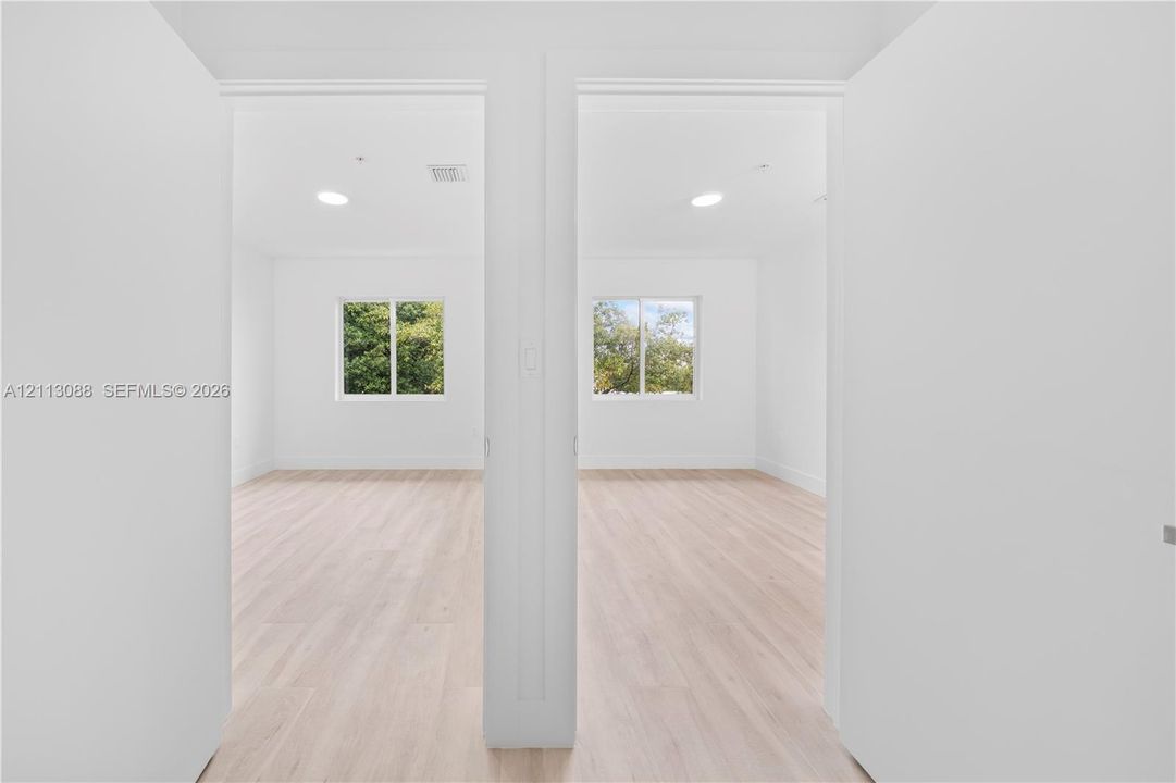 Interior space featuring light-toned wood-finish flooring, white walls, and recessed lighting throughout