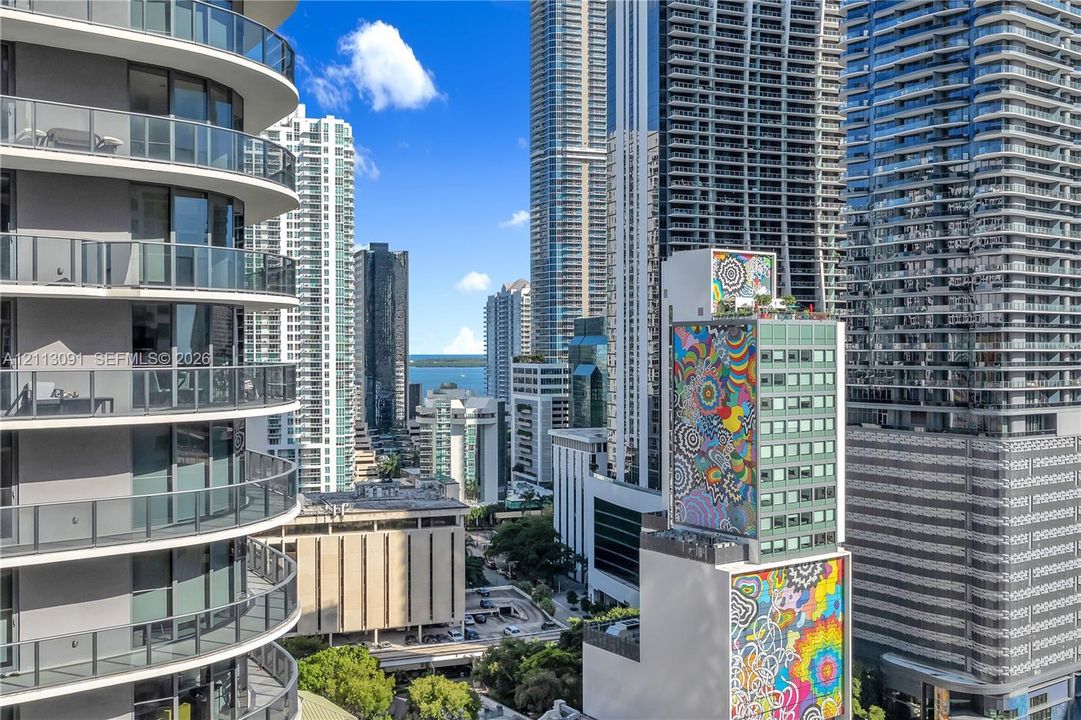 High-rise urban exterior featuring curved cantilevered balconies with glass railings