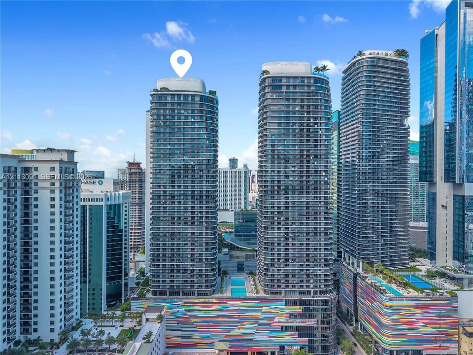 High-rise residential tower featuring a glass facade, private balconies, and a rooftop pool