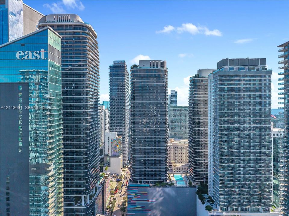 High-rise urban landscape featuring glass-clad skyscrapers, private balconies, and multi-level architectural structures