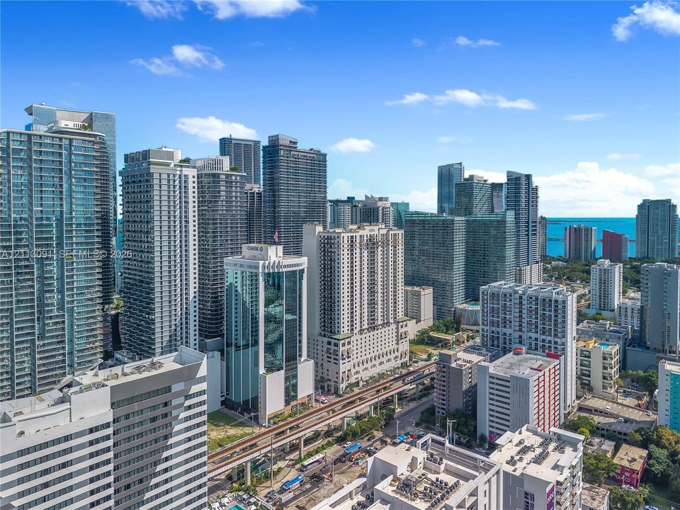 High-rise urban landscape featuring dense glass and concrete skyscrapers, expansive metropolitan skyline, and coastal horizon
