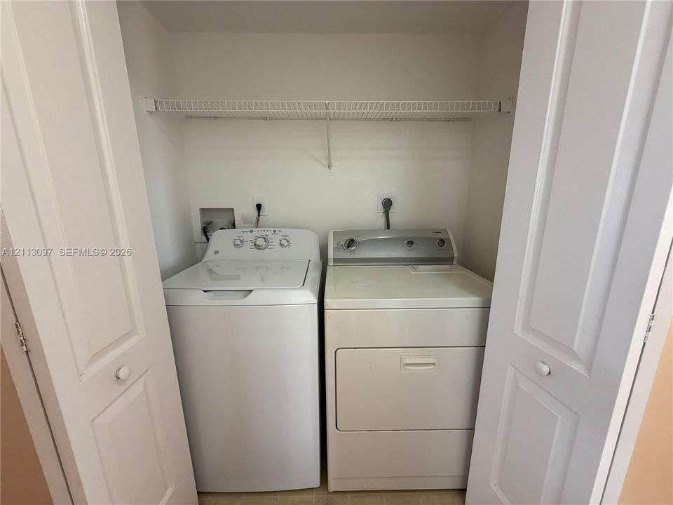 Laundry closet featuring bi-fold doors and overhead wire shelving