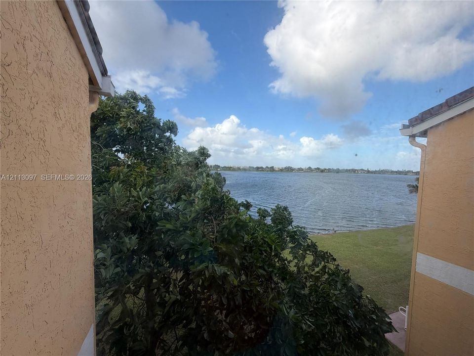 Stucco exterior walls, mature trees, and expansive water frontage
