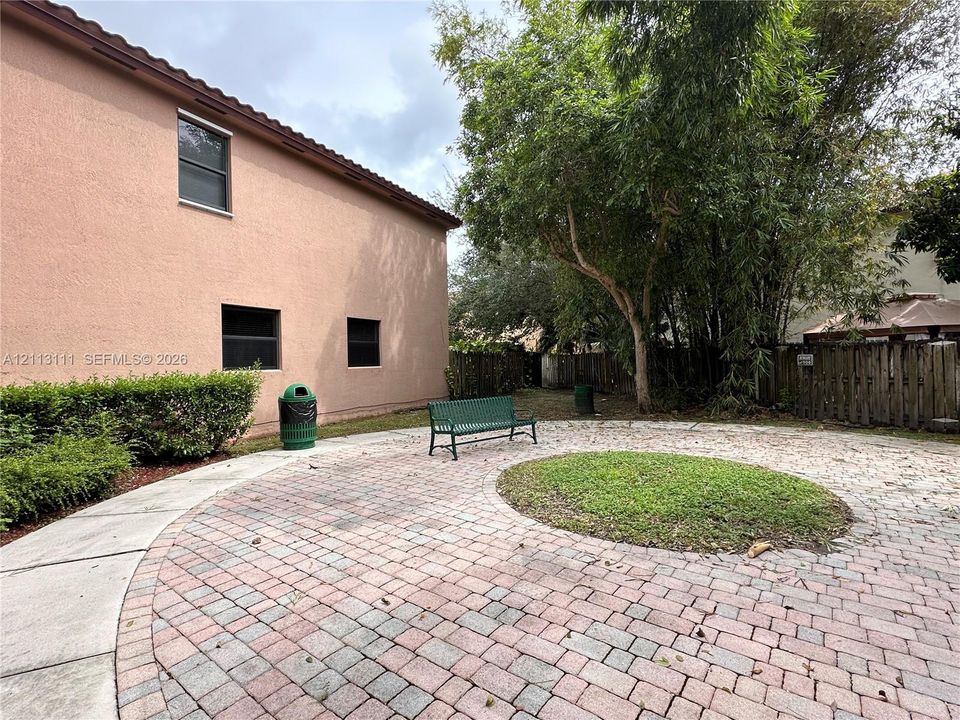 Plaza Patio, central lawn inlay, mature landscaping, and wood privacy fencing