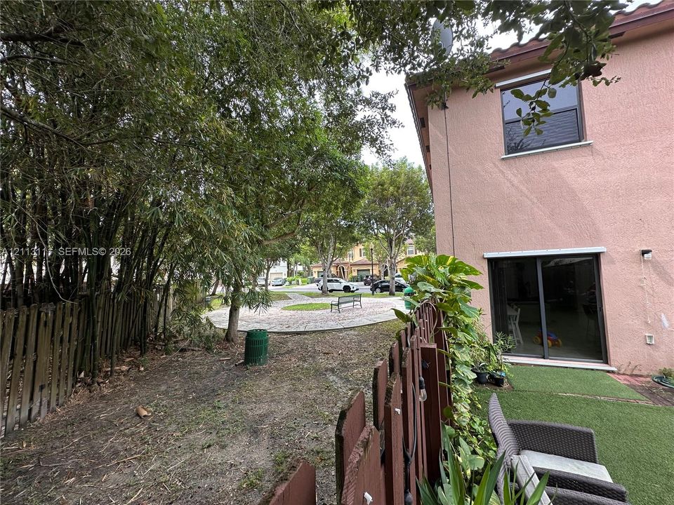 Stucco exterior featuring sliding glass doors and a wood-slat perimeter fence