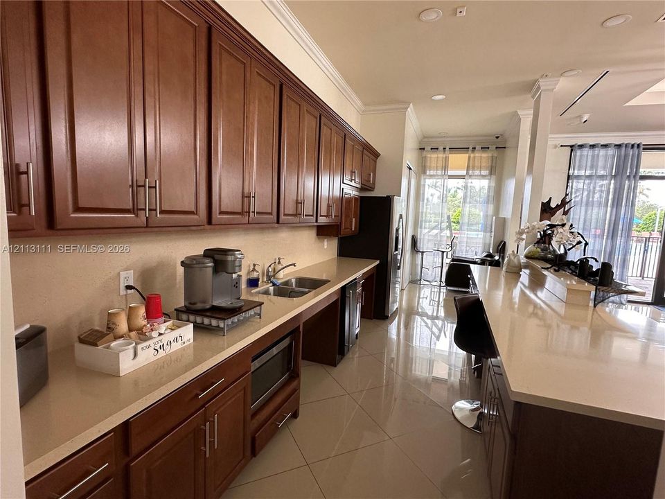 Kitchen featuring wood cabinetry, quartz countertops, tile flooring, recessed lighting, and a built-in microwave