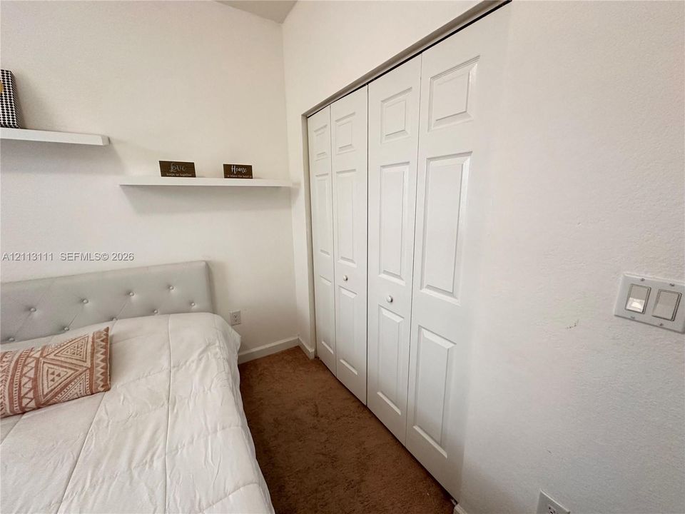 Built-in wall shelving and white paneled bifold closet doors