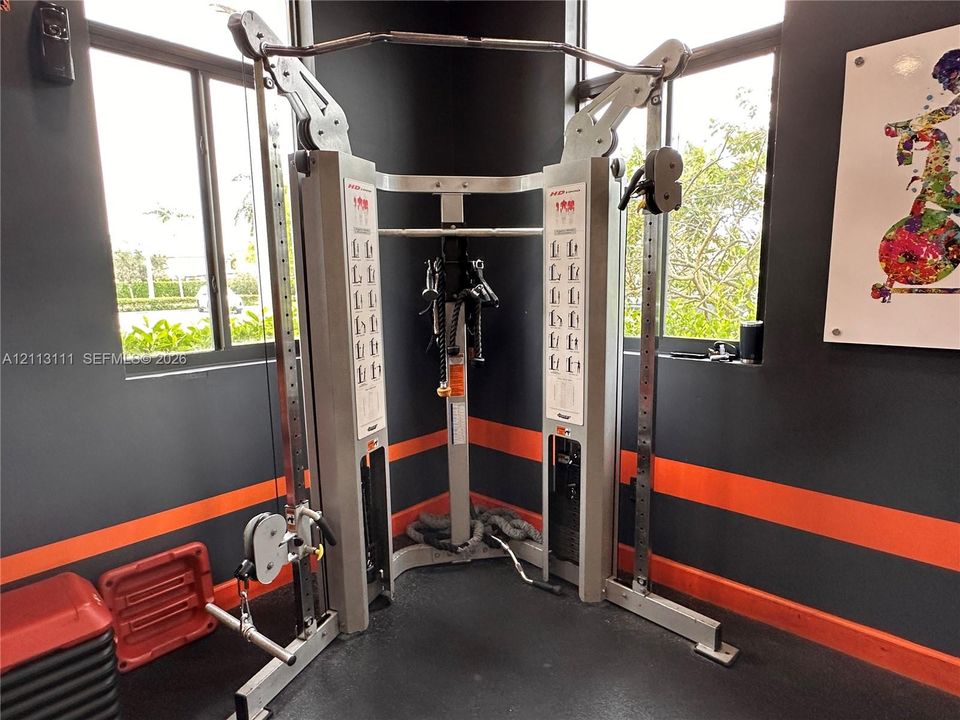 Corner fitness space featuring large windows and dark-toned wall finish