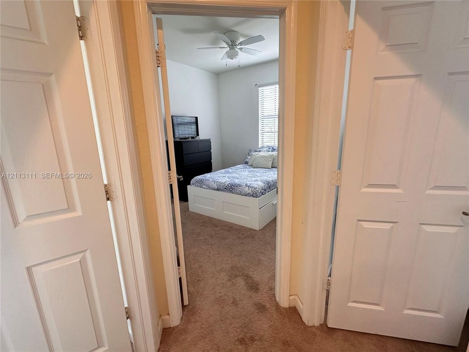Interior space featuring plush carpeting, multi-panel doors, and a ceiling fan