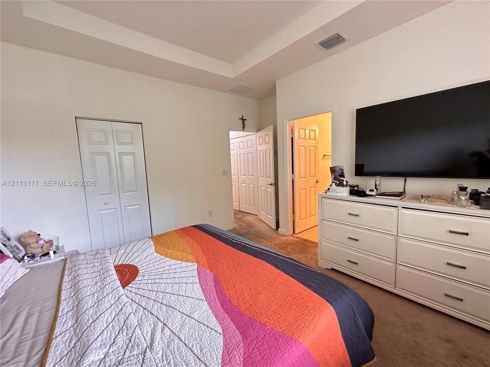 Tray ceiling, neutral wall tones, multi-panel doors, and carpeting