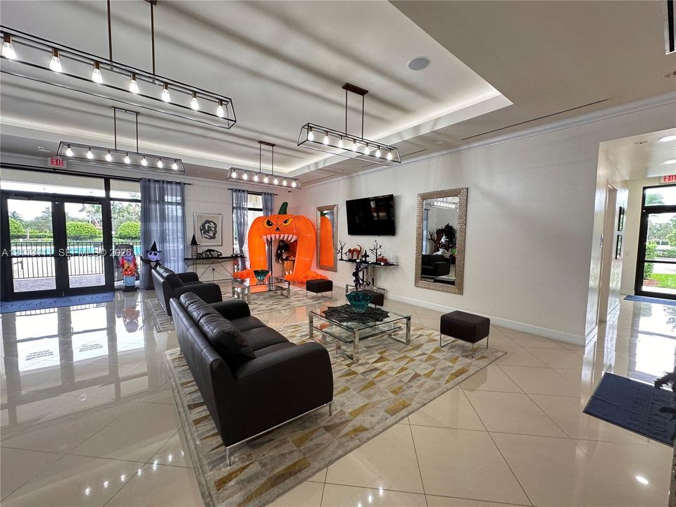 Open-concept room featuring tray ceilings with recessed lighting, large-format tile flooring, and multiple industrial-style rectangular pendant light fixtures
